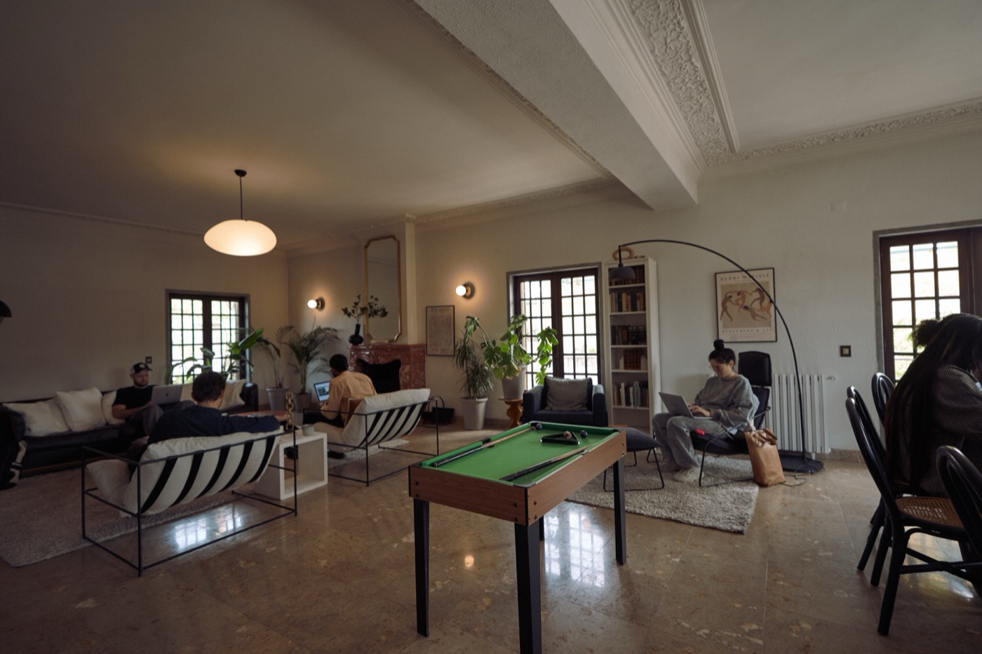 A group spread across the villa's main salon in session